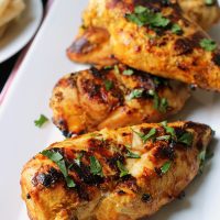platter of grilled chicken sprinkled with cilantro