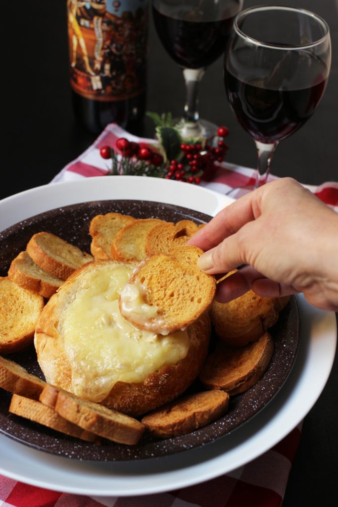 dipping bread into melted brie