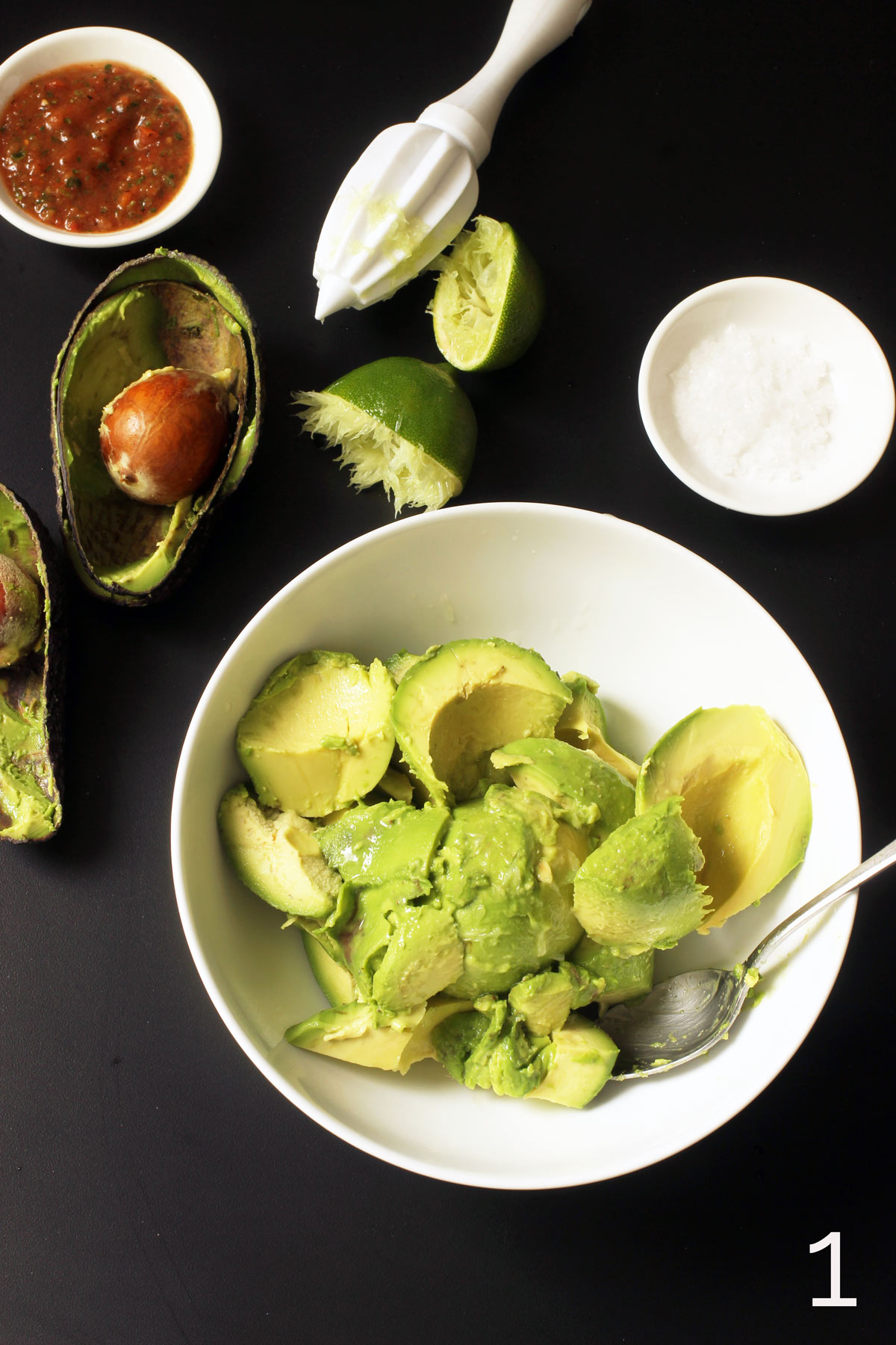 avocado scooped into bowl and lime juiced over the avocado chunks