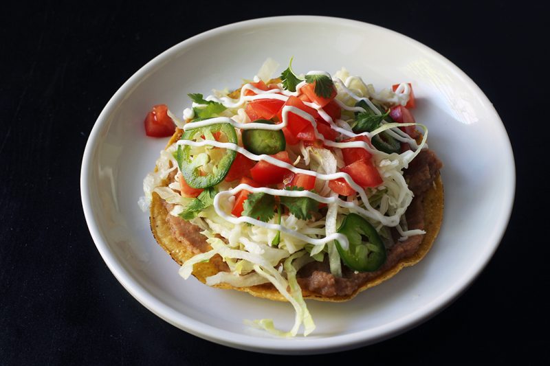 bean tostada on a white plate