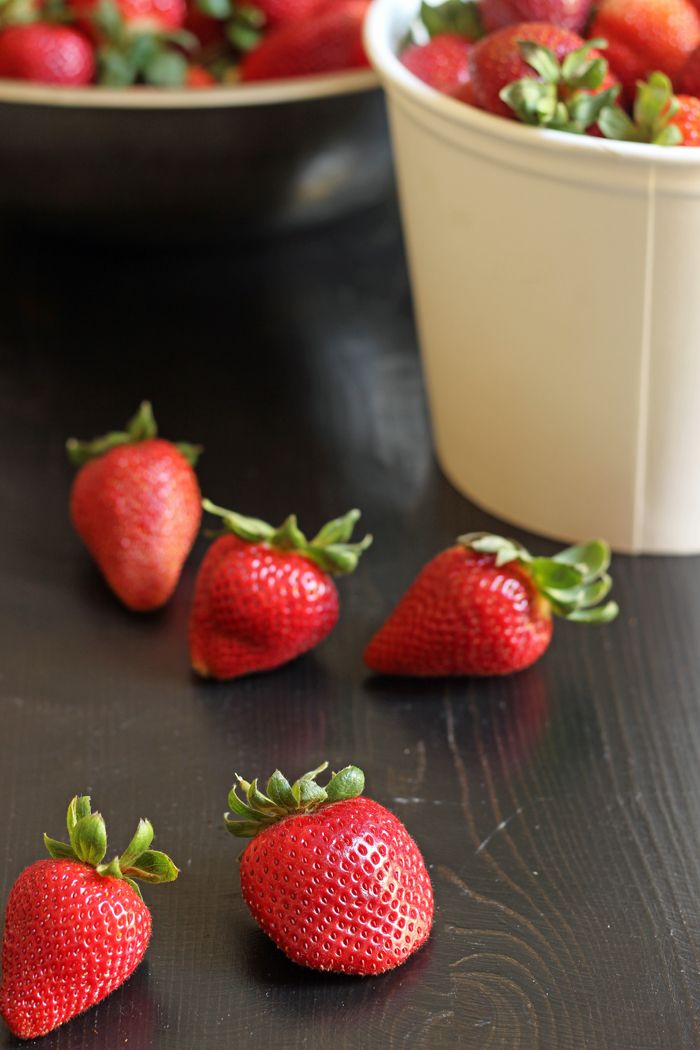 fresh picked strawberries in a white cardboard bucket