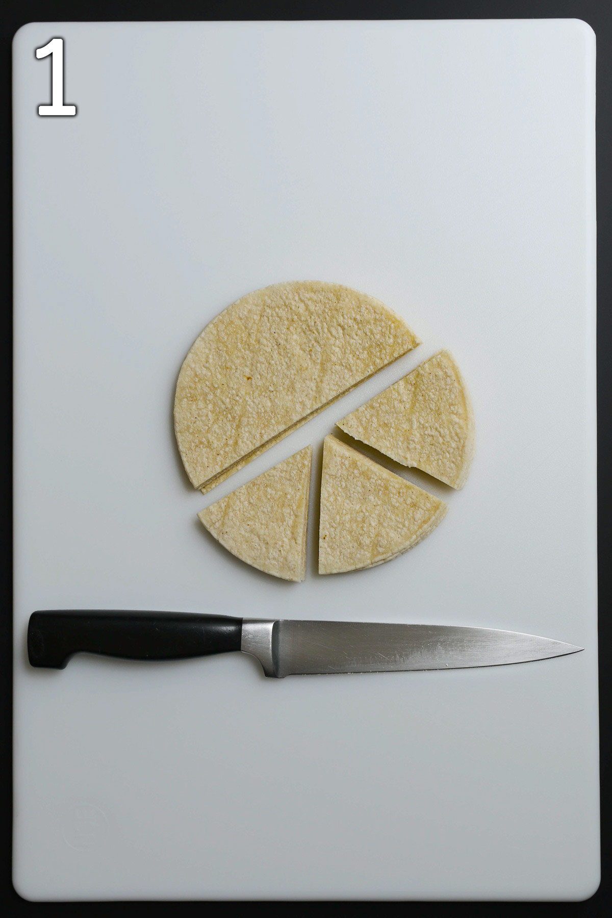 knife and stack of tortillas on cutting board, cut in half and one half cut into thirds.