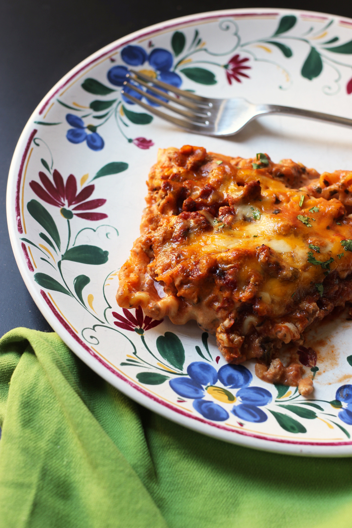 piece of lasagna on flowered plate with green napkin