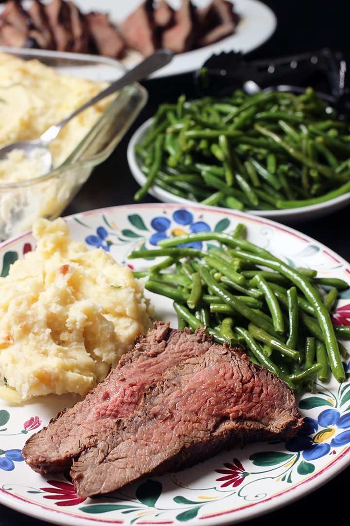 rare steak on dinner plate with potatoes and green beans