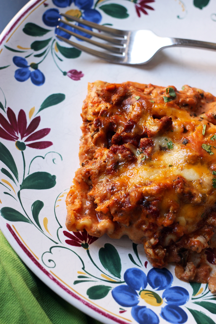 square of lasagna on plate with fork