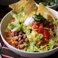 bean and rice bowl with chips and toppings