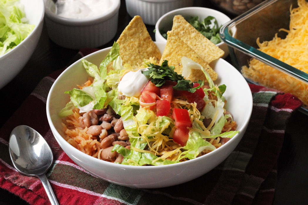 A bowl of rice and beans with toppings