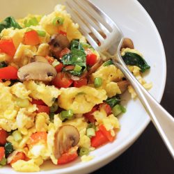 white ceramic bowl of greek eggs with fork