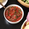 a bowl of salsa with a spoon