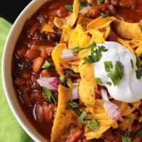 bowl of chili with toppings and fritos