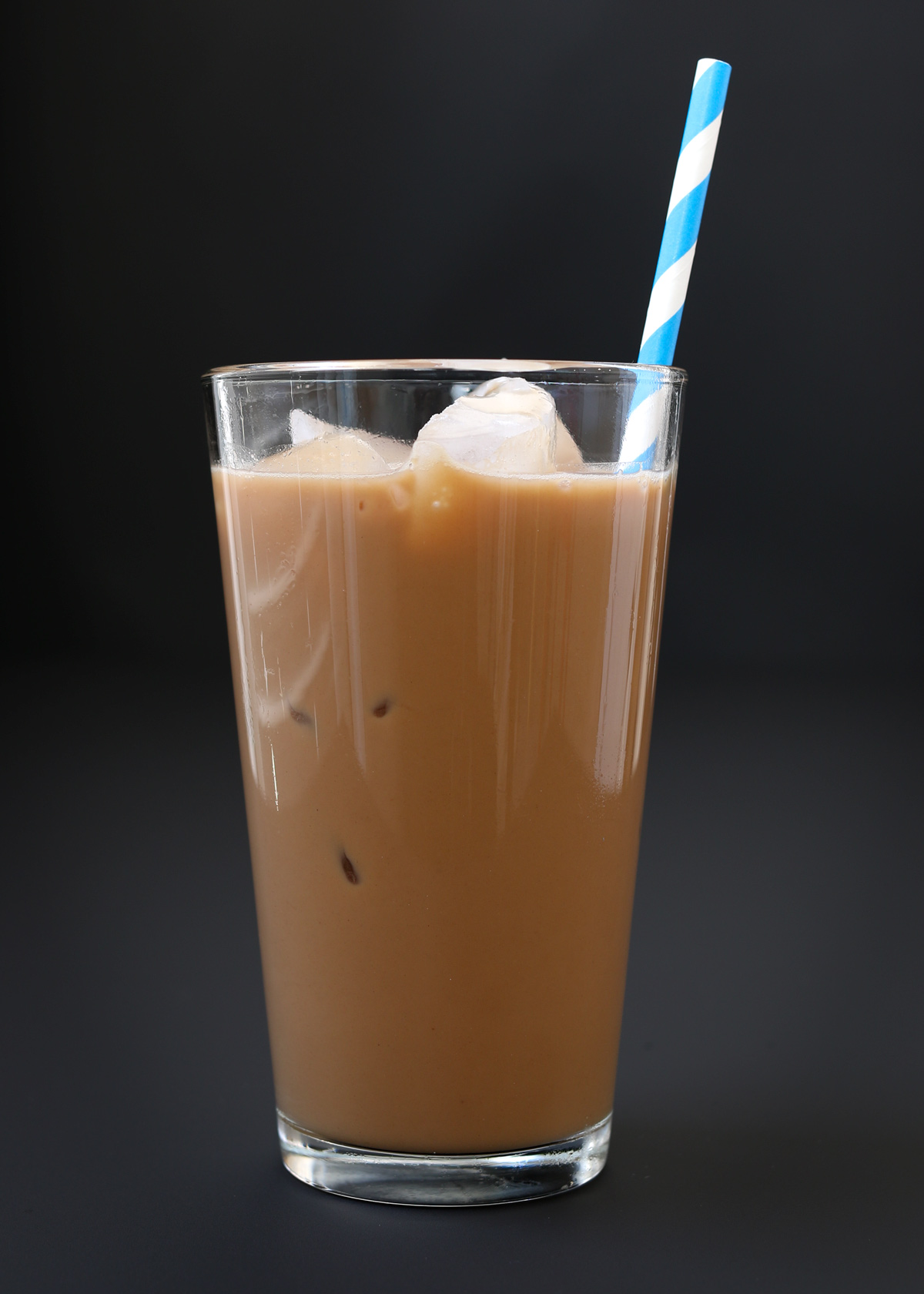 iced mocha in tall glass with blue striped straw.