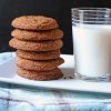 Snickerdoodles stacked next to glass of milk