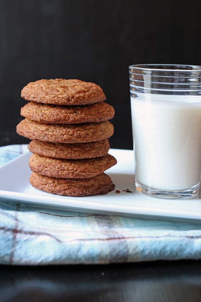 Snickerdoodles stacked next to glass of milk