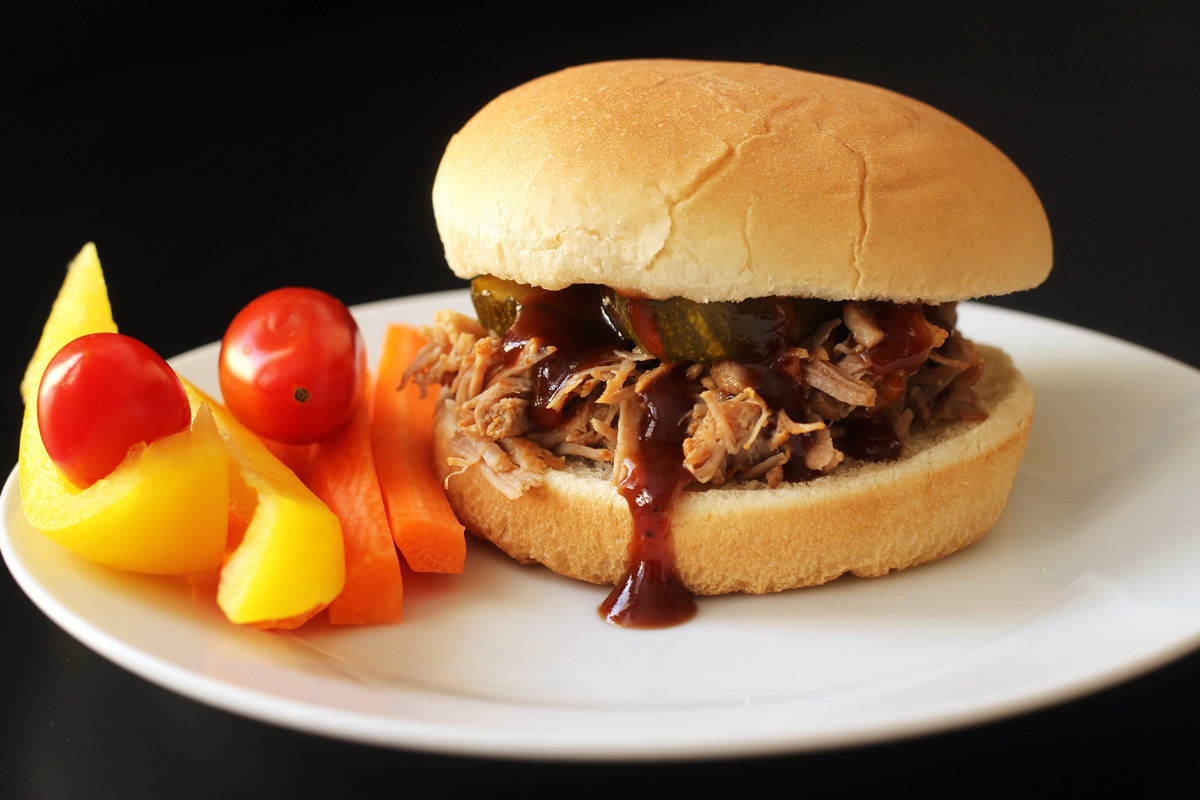 BBQ pork sandwich on plate with veggies