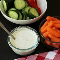 bowl of tzatziki dip with bowls of vegetables