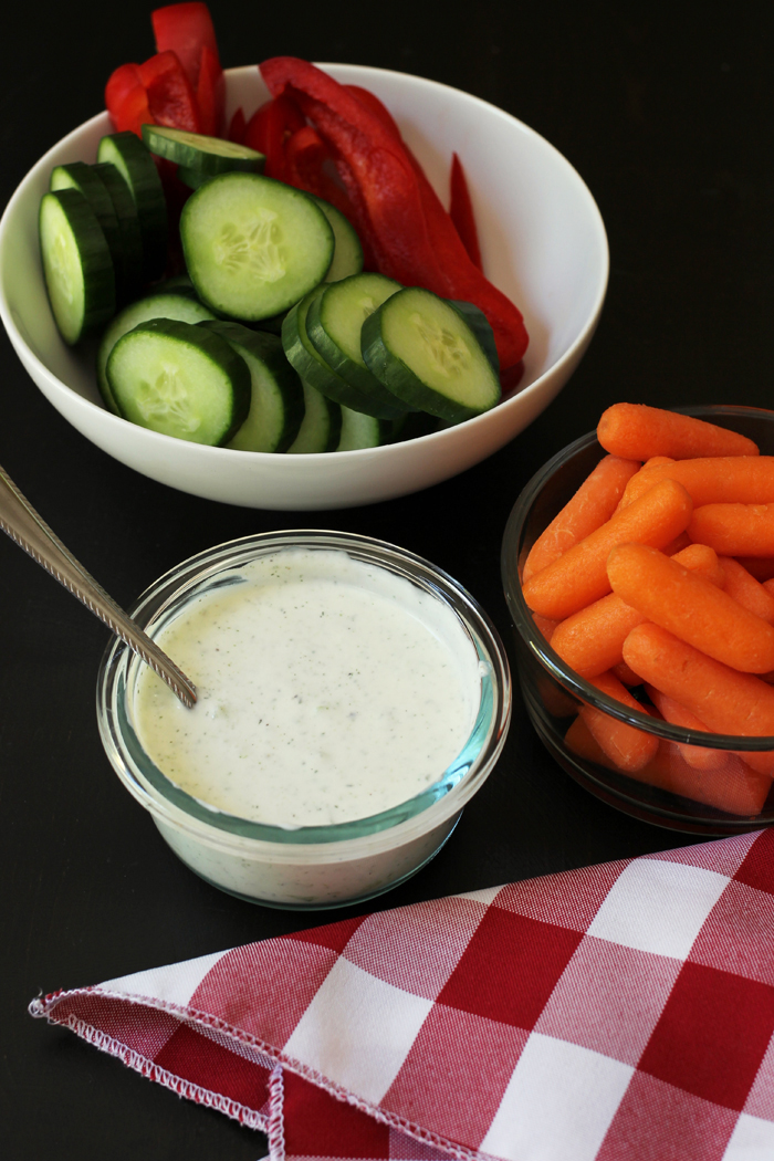 bowl of tzatziki dip with bowls of vegetables