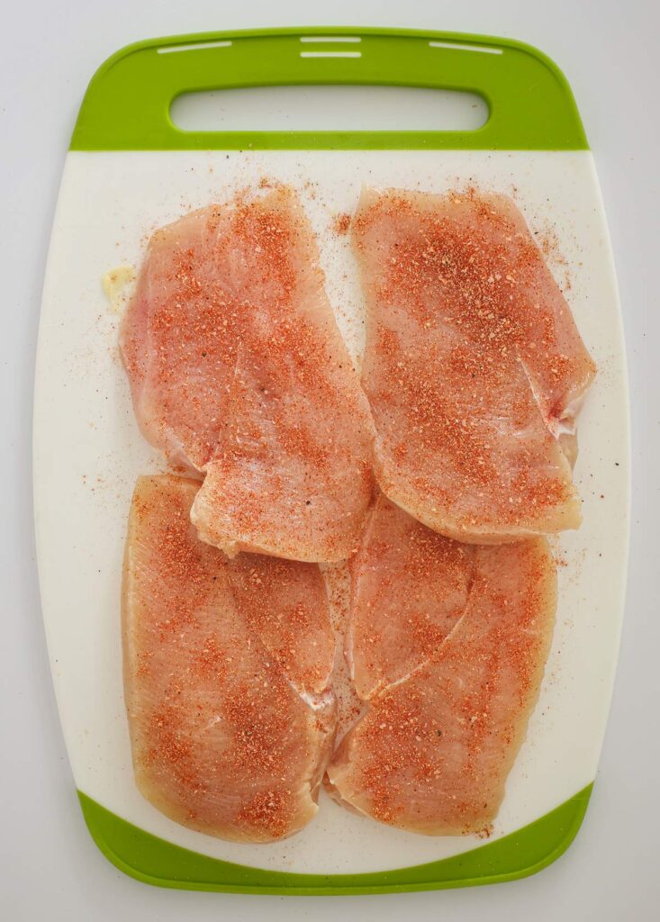 cutlets on cutting board, seasoned with spice mix.