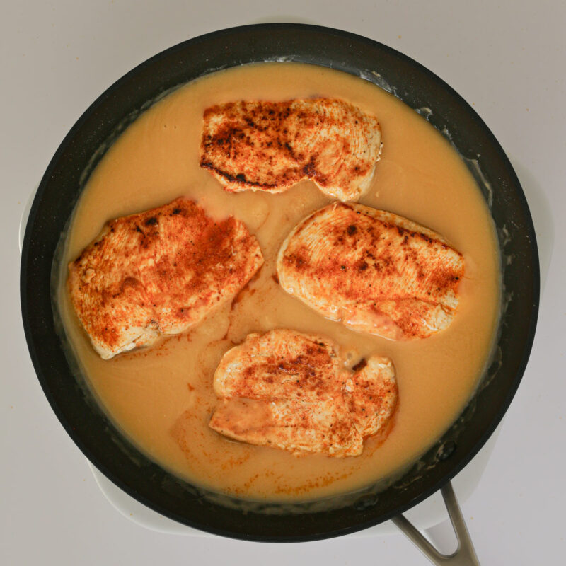 chicken reheating in the pan of gravy.