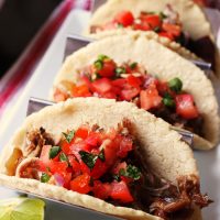 taco rack with three carnitas tacos