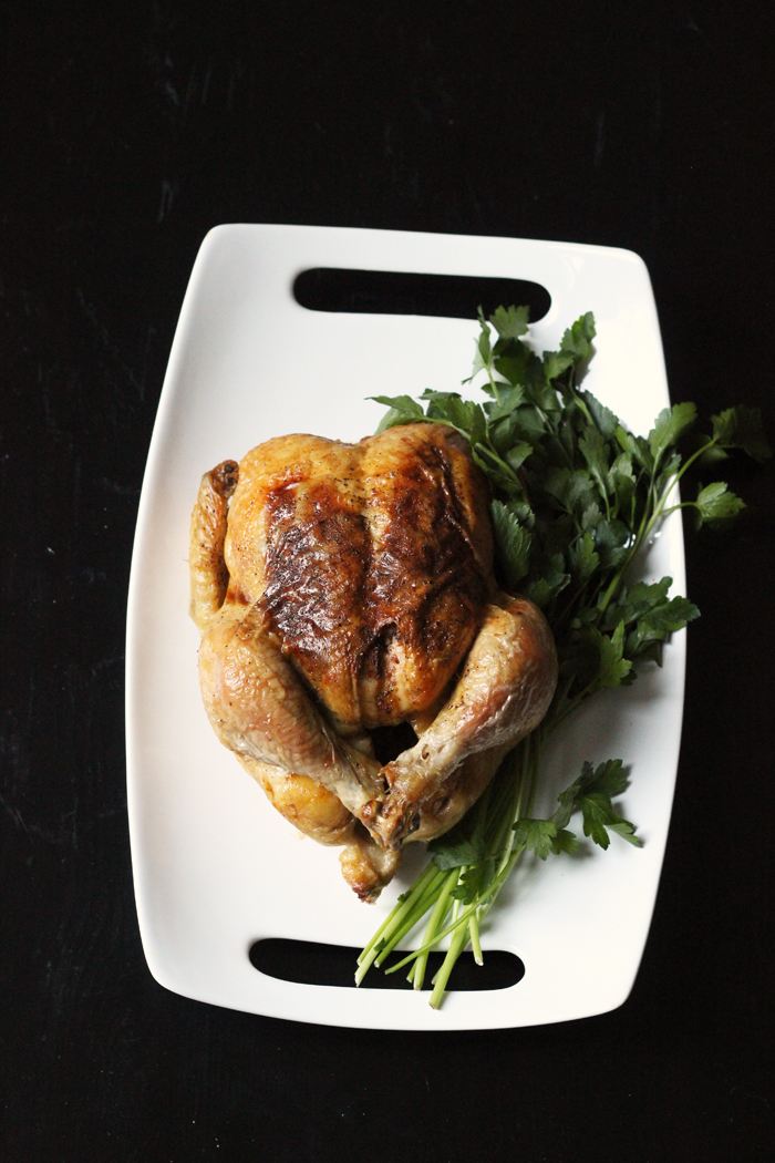 un poulet entier et des herbes sur un plateau