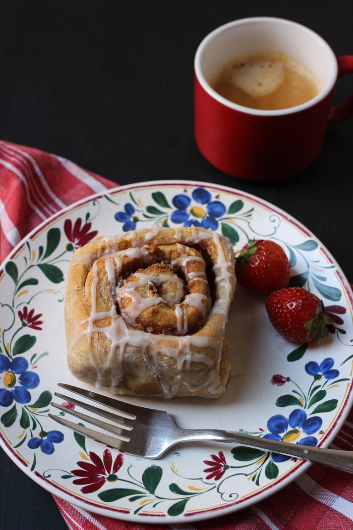 cinnamon roll and strawberries on a plate