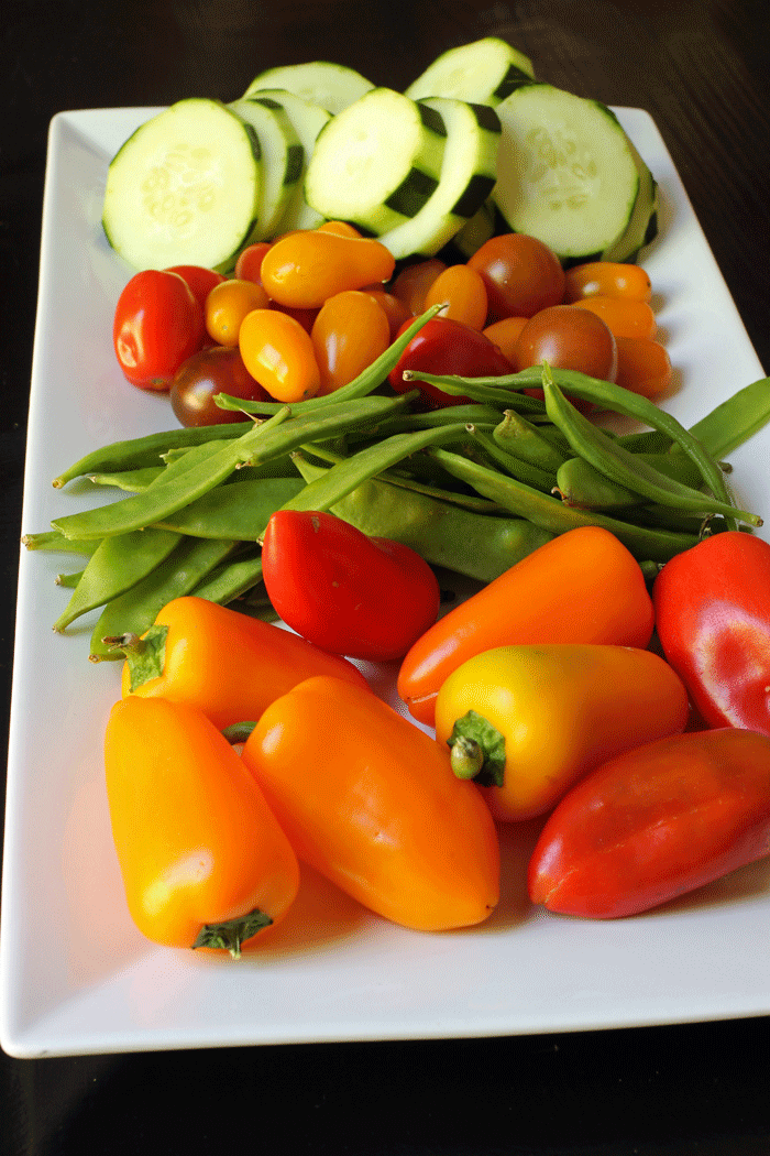 vegetable tray with cucumbers, tomatoes, peas, and peppers