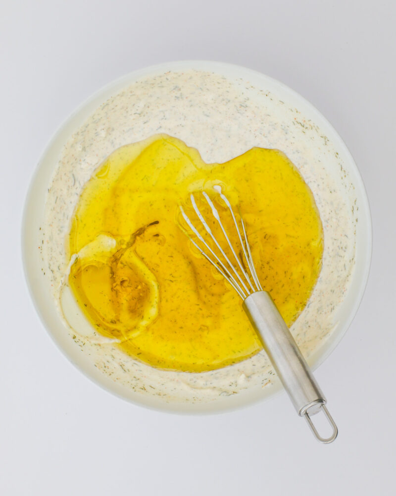 adding oil to the first ingredients in the bowl.