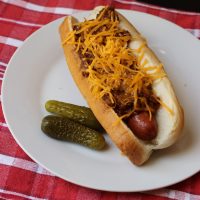 chili dog on plate with pickles