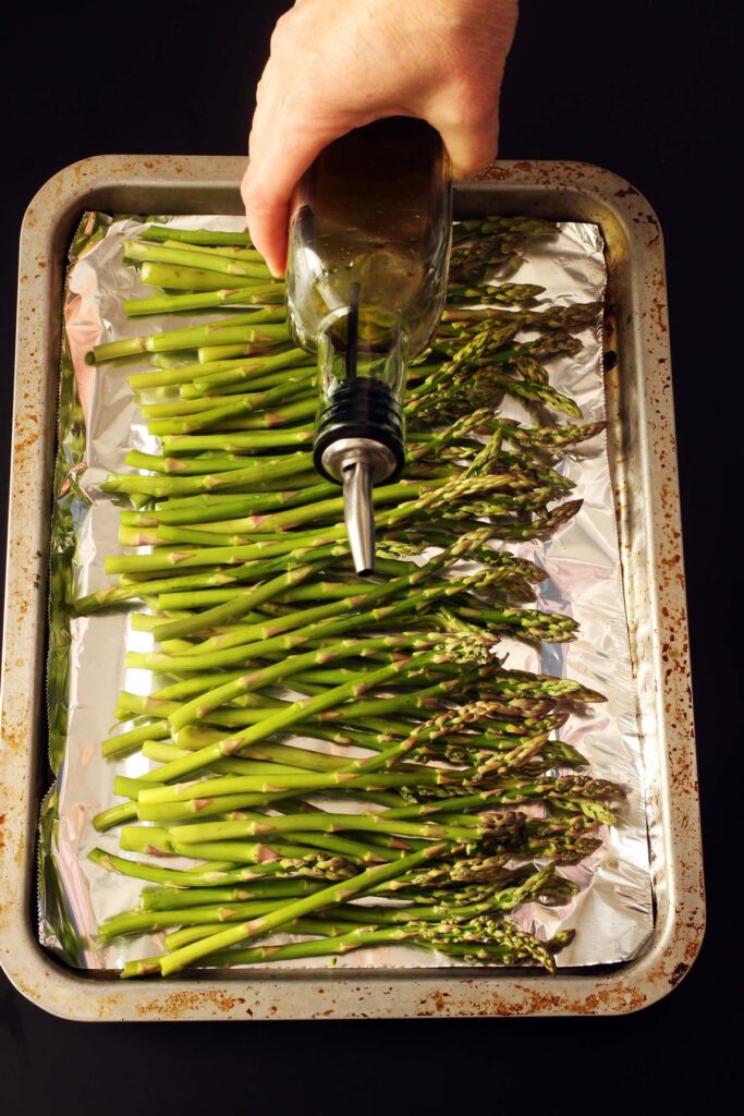 pouring oil on asparagus