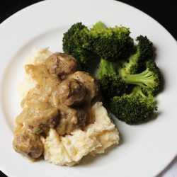 A plate of meatballs, mashed potatoes, and broccoli