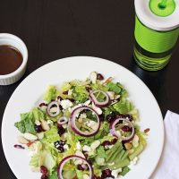 A plate of salad with cranberries