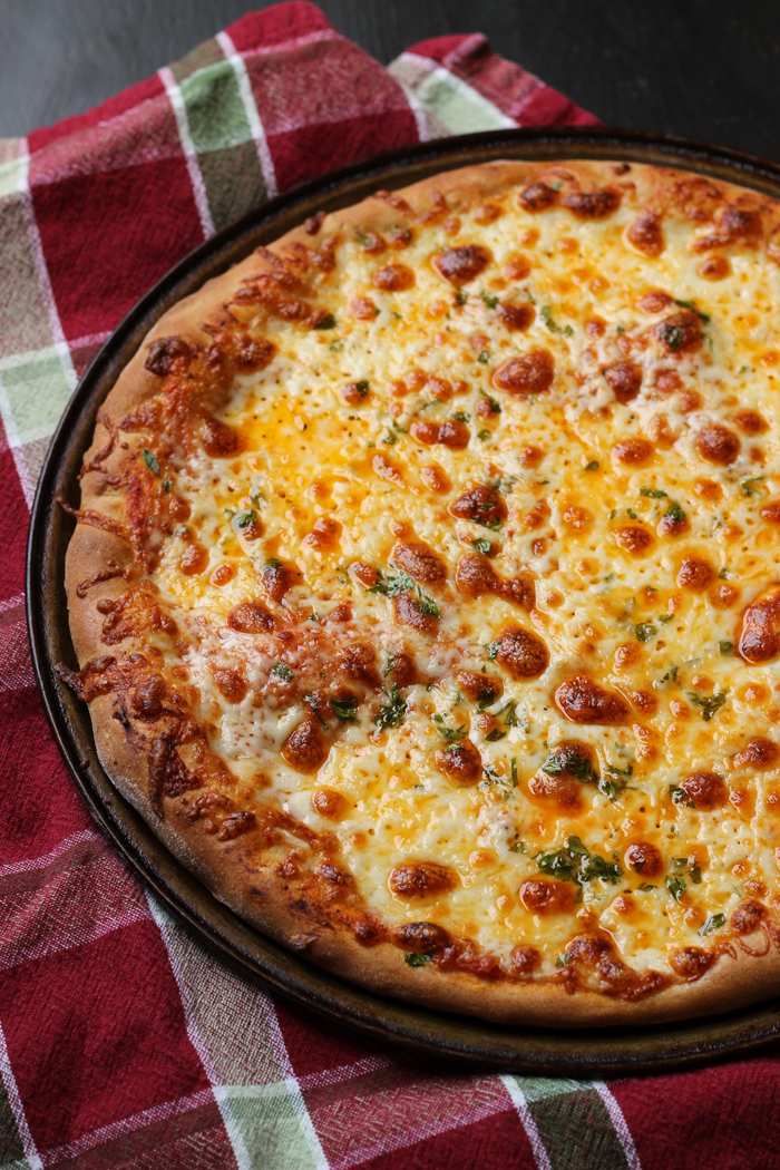 A pizza sitting on top of a pan on a table, with Cheese