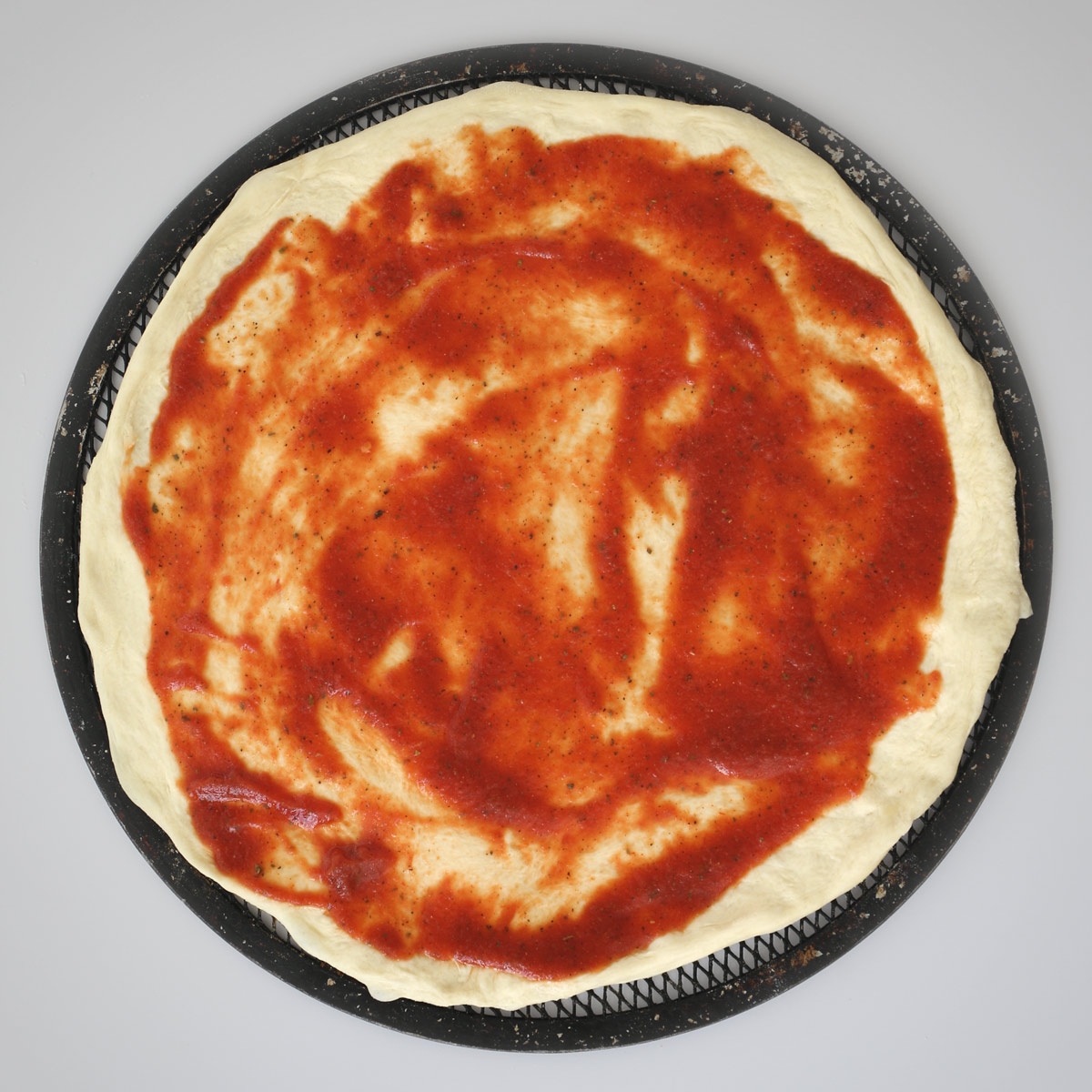 sauce spread on pizza crust.