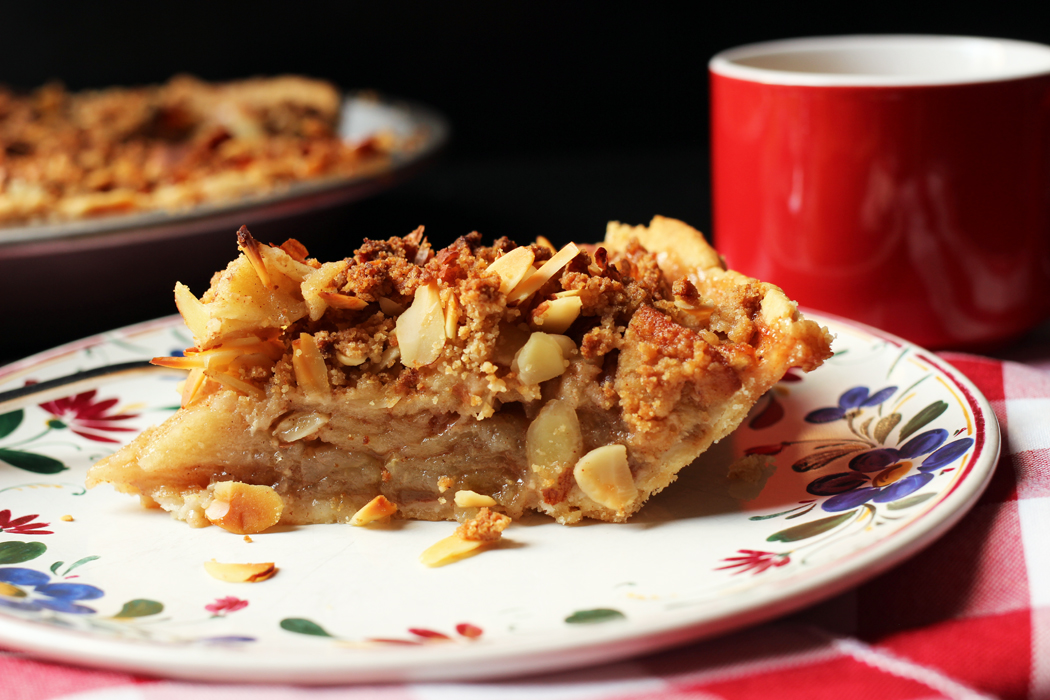 slice of apple pie on a plate with coffee cup on the side