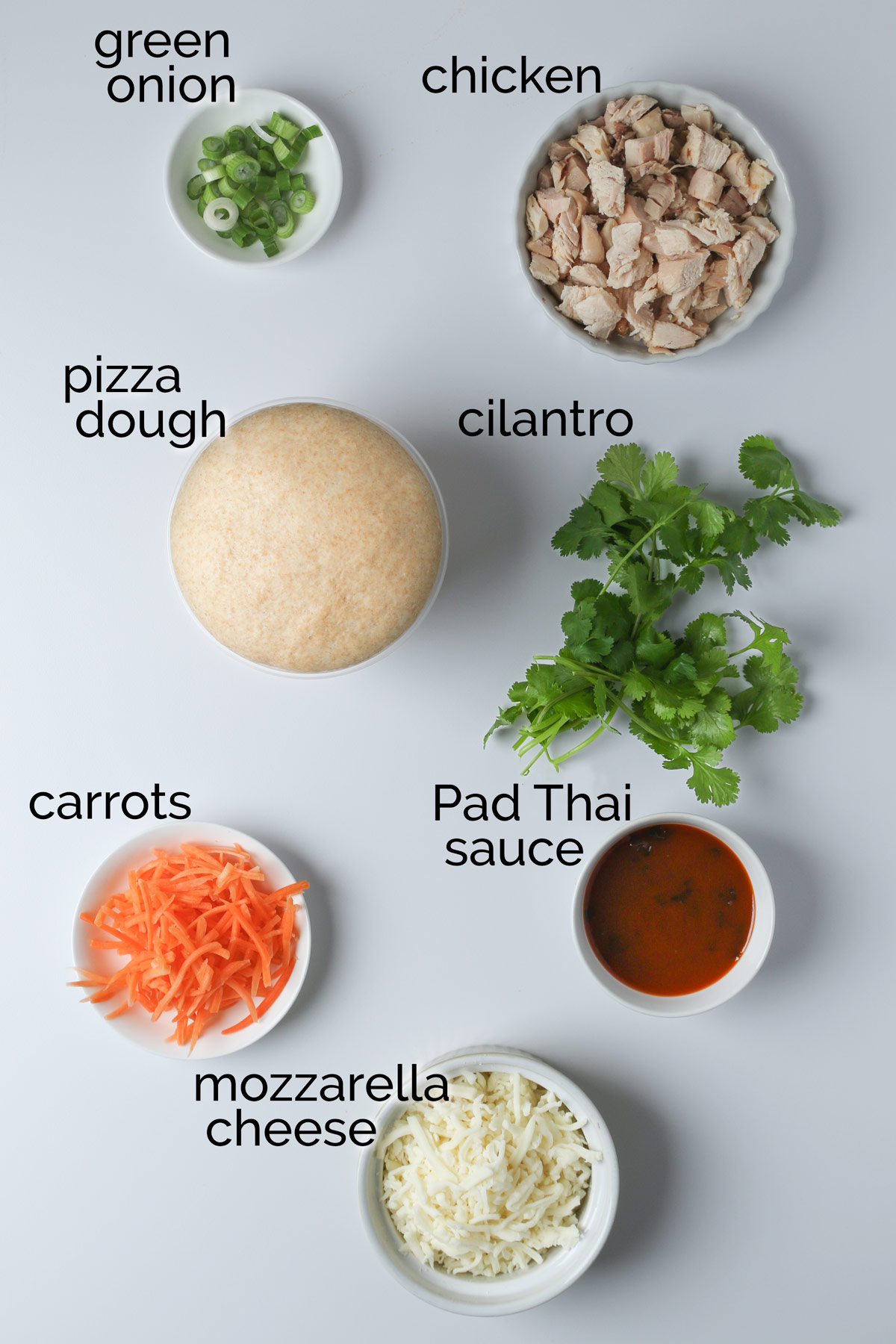 ingredients for Thai chicken pizza laid out on counter.