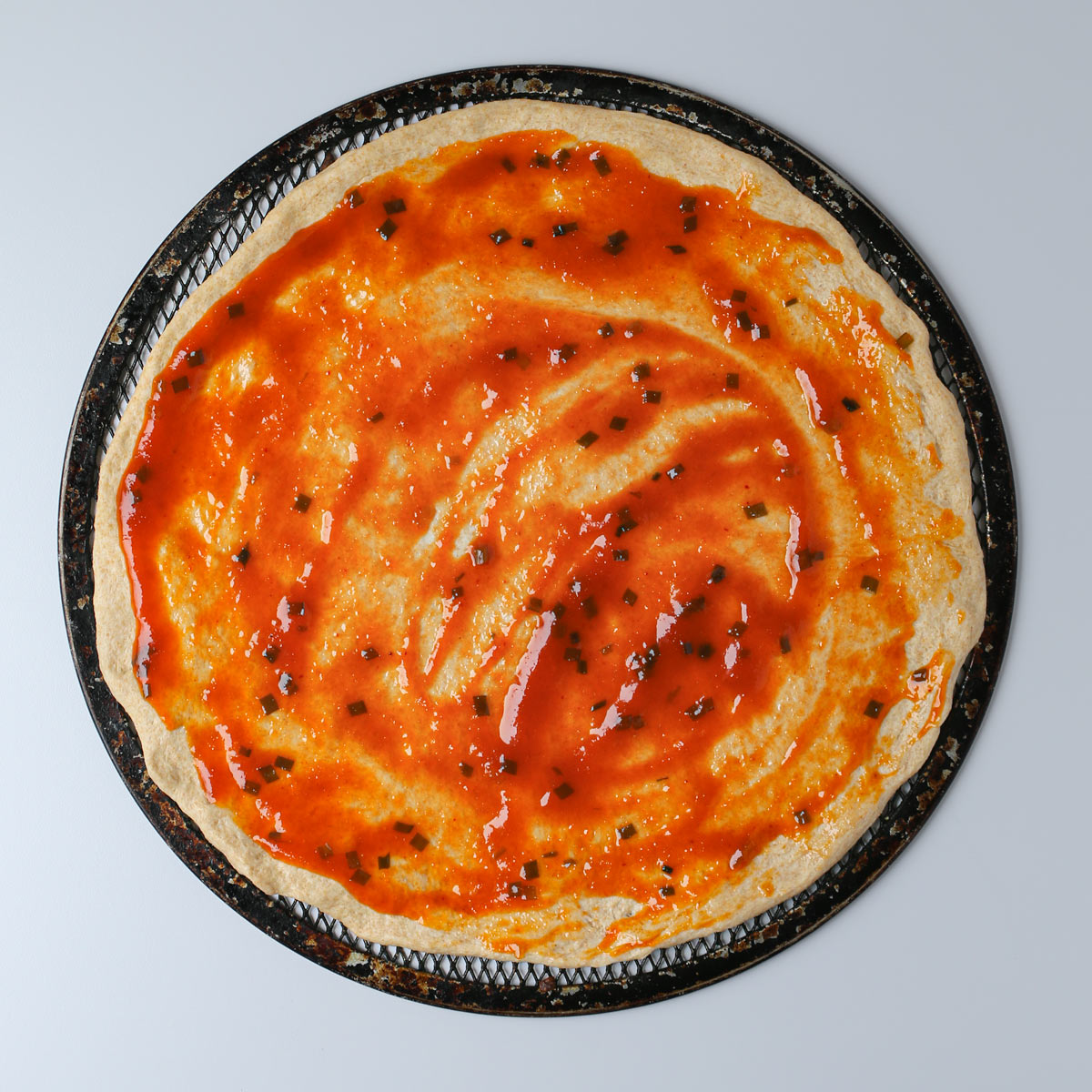 sauce spread on pizza crust.