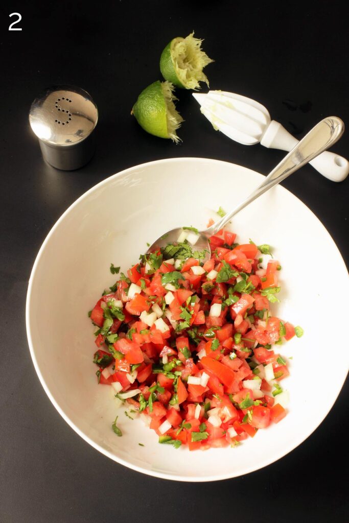 stirring pico ingredients with large spoon in the white bowl.