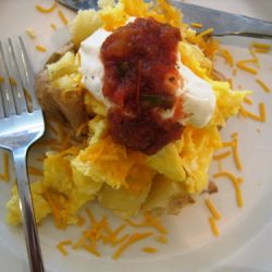 loaded breakfast potato on a plate with fork