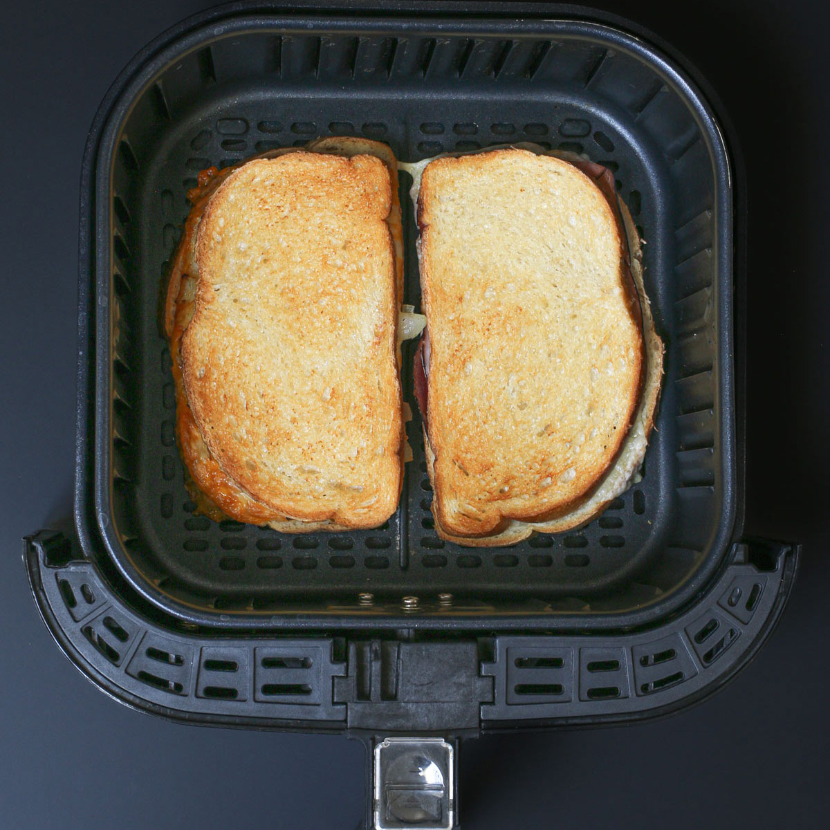 two air fryer grilled cheese sandwiches in basket.
