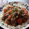 bowl of beef eggplant stew next to napkin and spoon