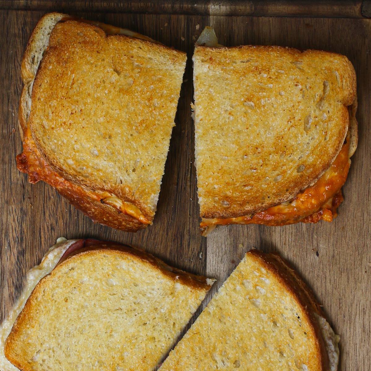 air fryer grilled cheese sandwiches on board, cut in half.