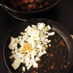 sauteeing onion and garlic in skillet next to crockpot
