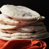 stack of pita breads near orange napkin