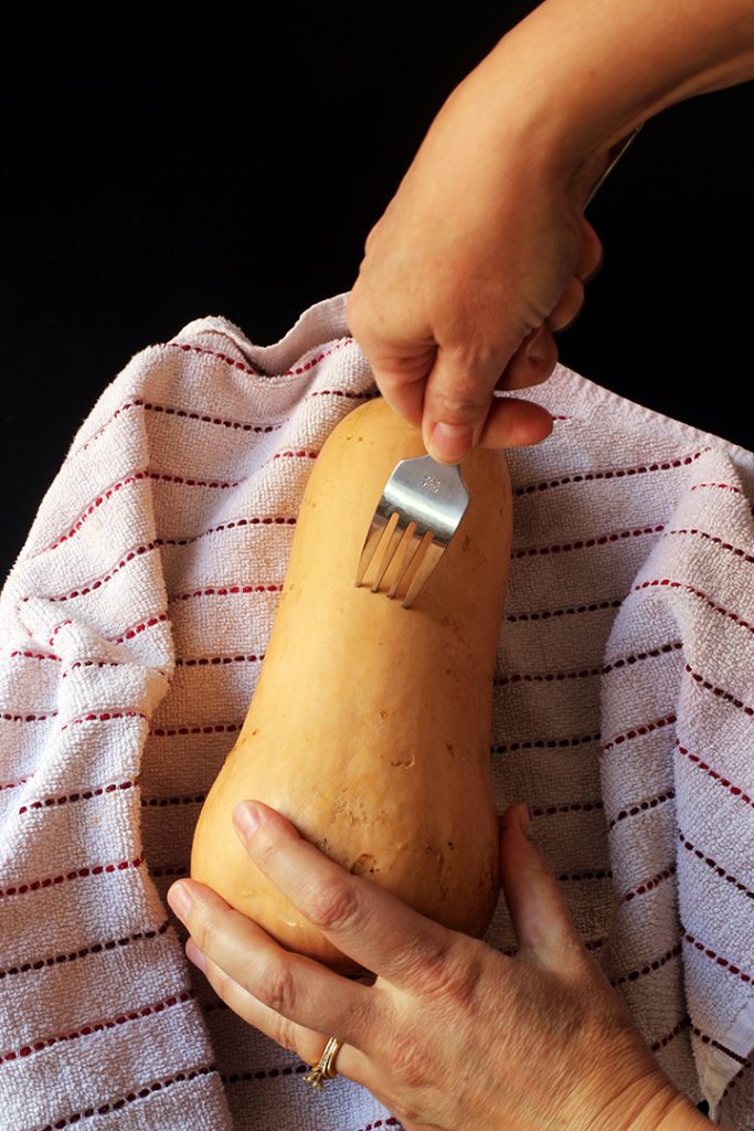 A close up of a hand forking holes in squash