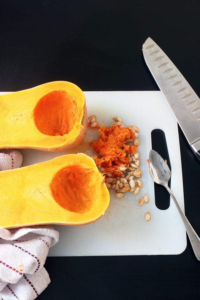 Squash halves on cutting board with pile of seeds