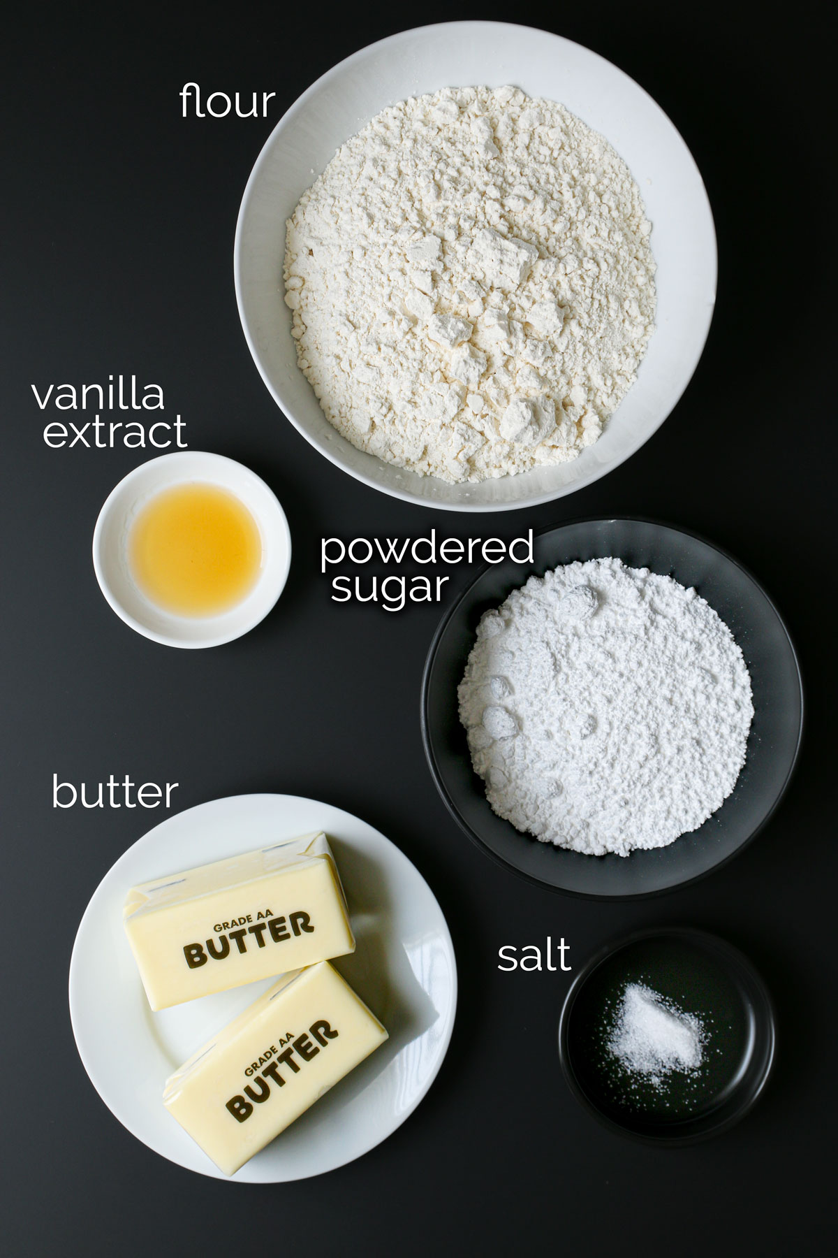 ingredients for snowball cookies on black counter.