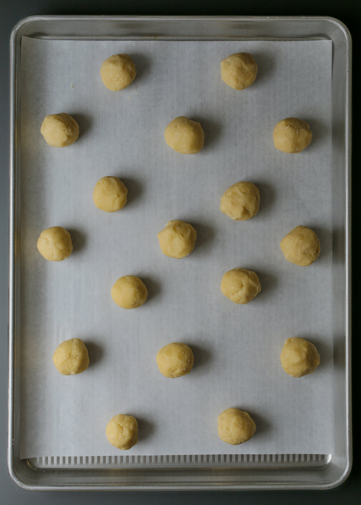 dough balls on parchment-lined tray.