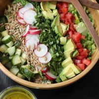 A bowl of chopped salad with radish and avocado