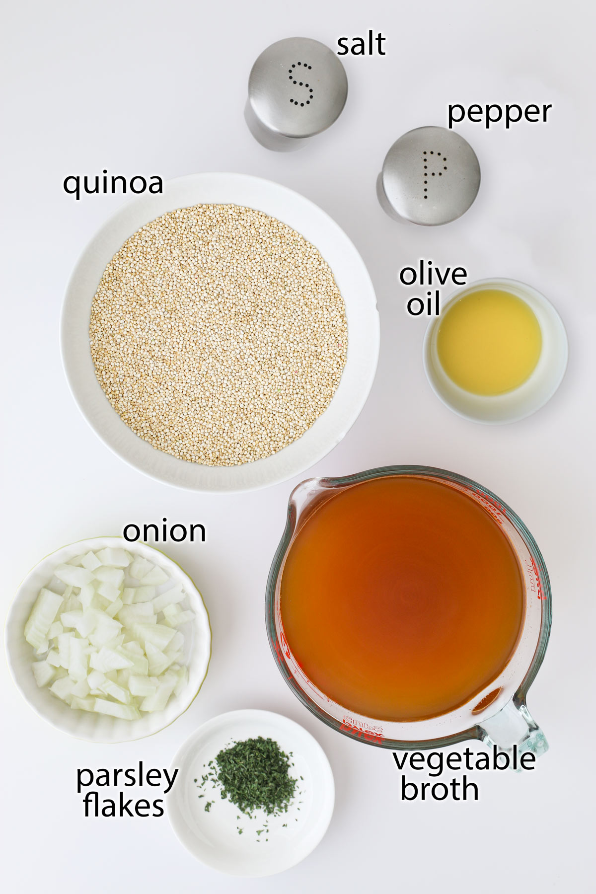 ingredients to make quinoa pilaf laid out on a white counter.