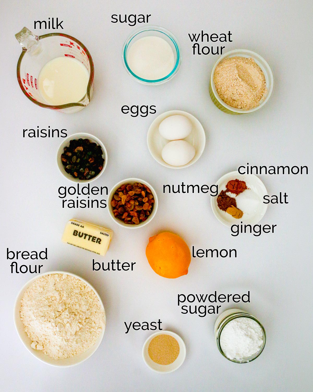 ingredients for hot cross buns, laid out on white counter.